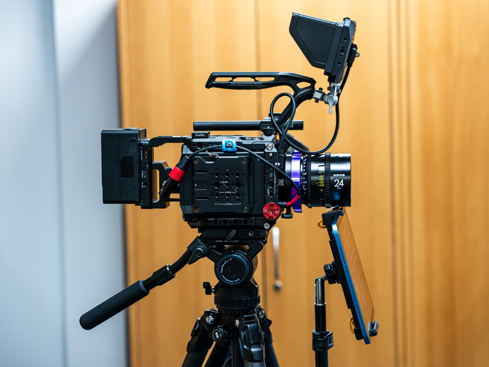 A cinema camera on a tripod with an iPad mounted directly beneath the lens, rigged for a prompted piece to camera.